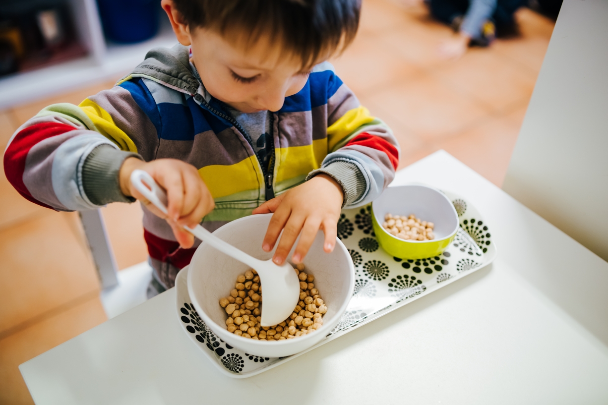 Kind im CreaVita Kinderhaus bei einer Schüttübung aus den Übungen des praktischen Lebens